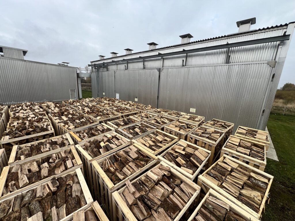 Kiln-dried firewood crates in front of Vudlita drying chambers